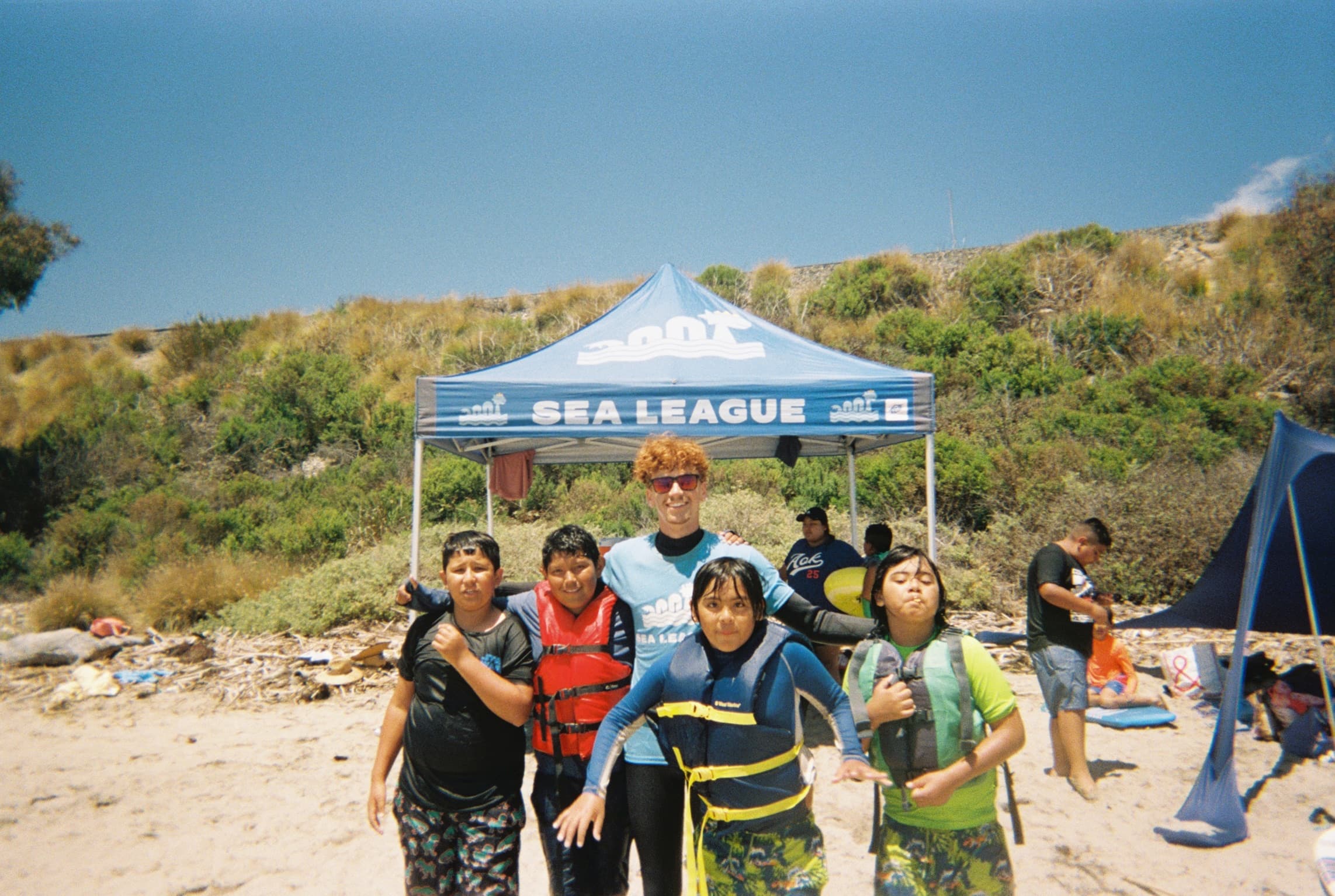 Sea League coaches with a group of kids at the shore